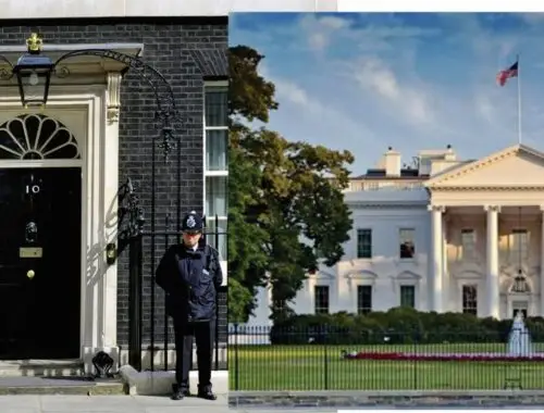 A police officer standing in front of a white house Description automatically generated